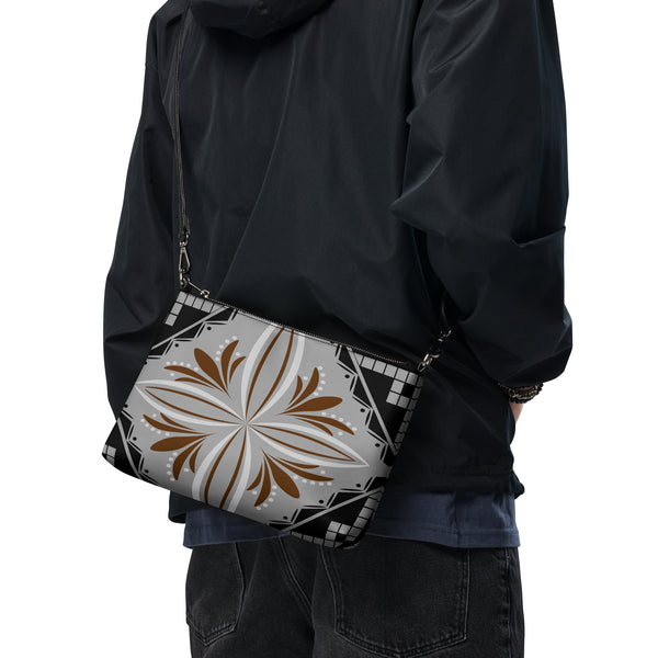 Ce sac à main, aux motifs tapa, est parfait pour vos soirées. Avec son look unique et sa pratique bandoulière, vous pourrez l'emporter partout avec style et facilité.